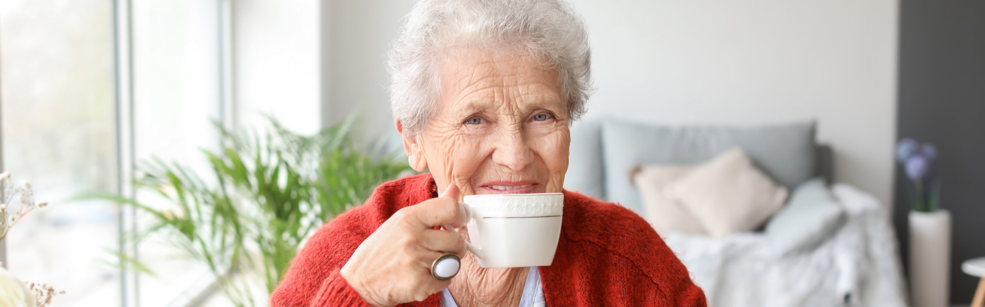 elderly woman holding a tea in a cup