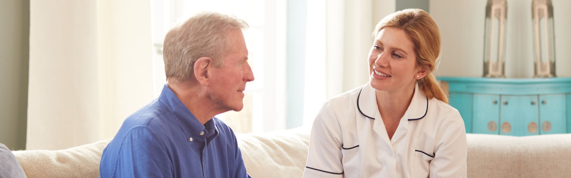 elderly man and female aide talking